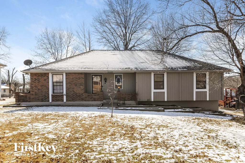 A house with a snow-covered roof and a snow-covered lawn.
