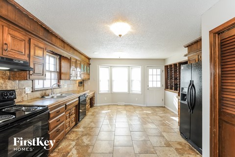 A kitchen with a black stove top oven and a black refrigerator.