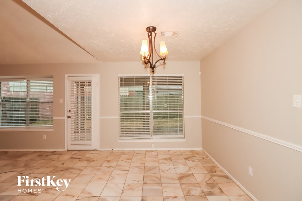 a dining room with a large window and a chandelier