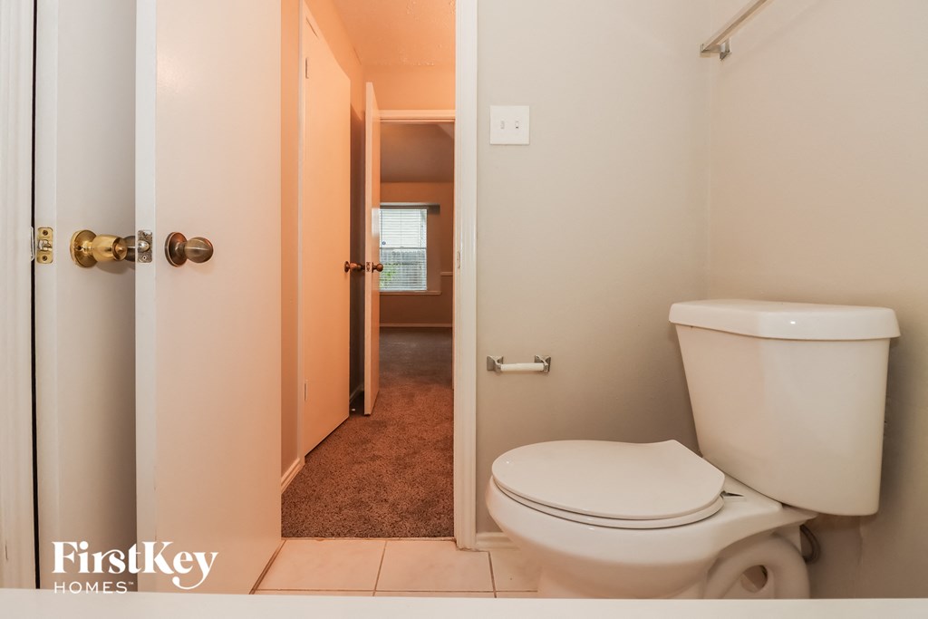 a bathroom with a toilet and an open door to a hallway