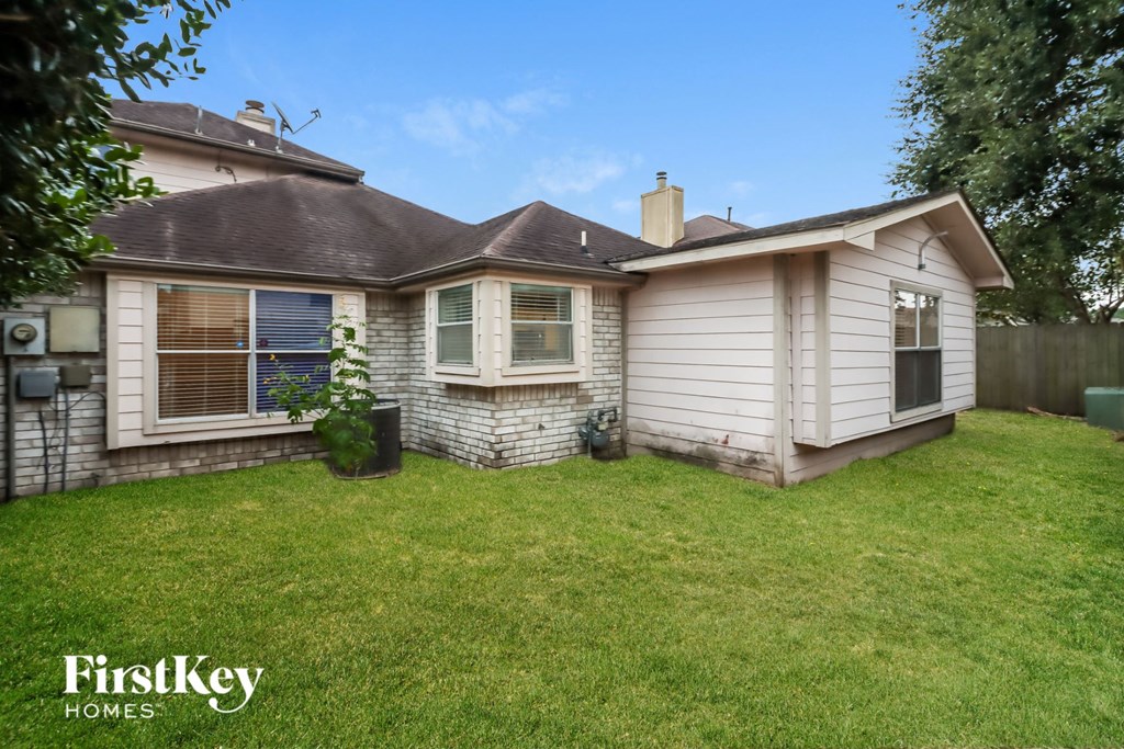 the backyard of a house with a lawn and a fence