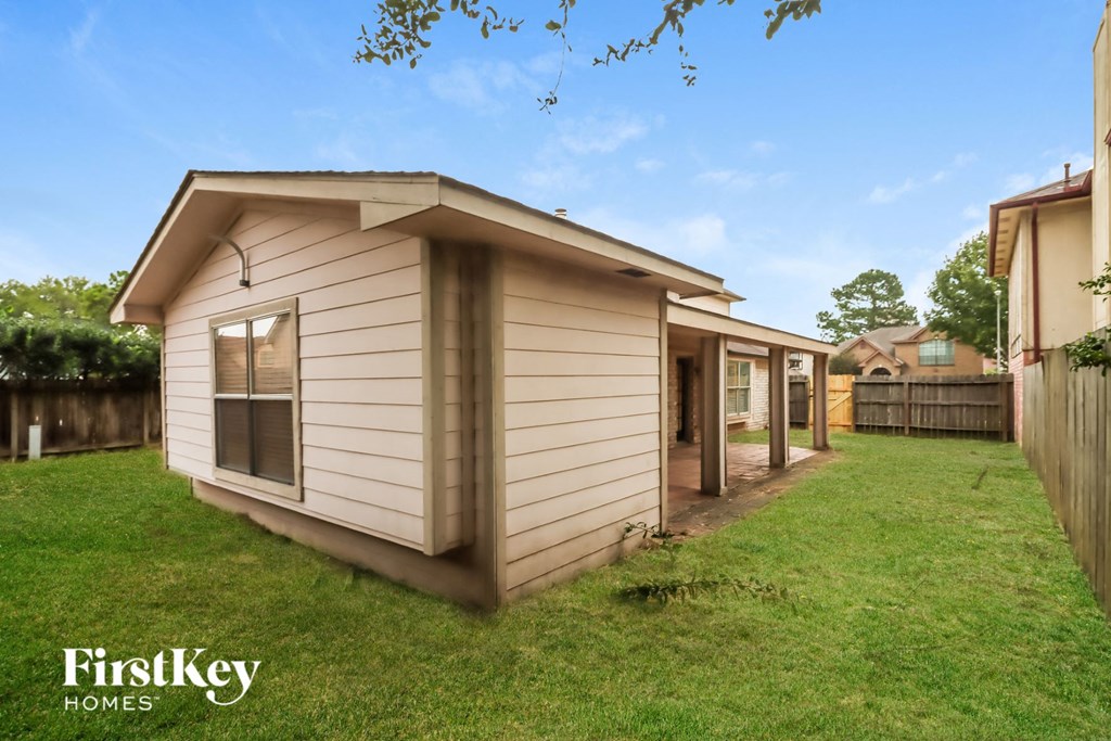 a small wooden shed in the backyard of a house