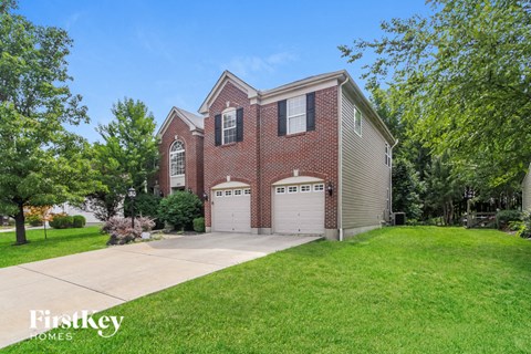 A brick house with a garage is for sale.