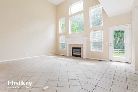 A spacious room with a fireplace and large windows.