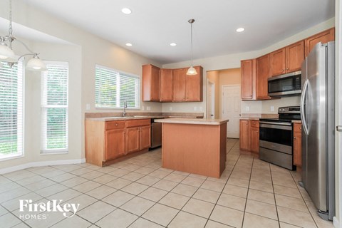 A kitchen with wooden cabinets and a refrigerator.