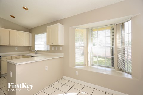 A kitchen with white cabinets and a white counter top.