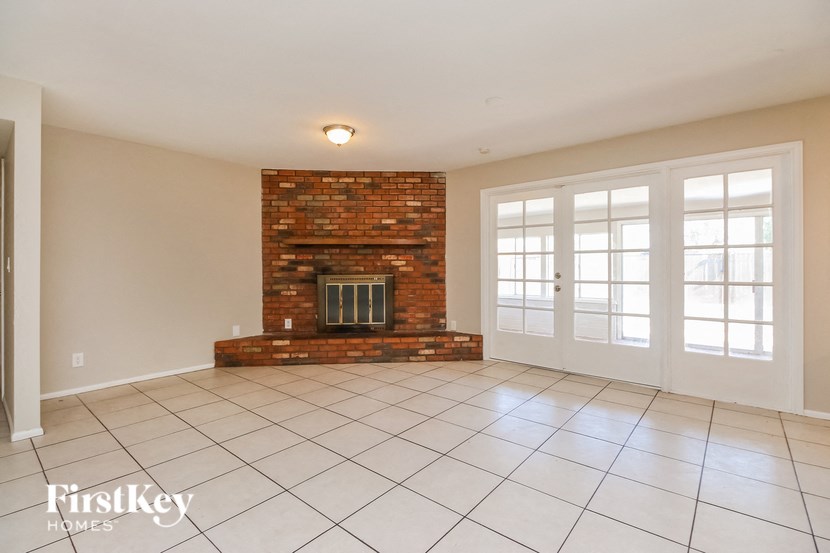 a living room with a fireplace and a tiled floor