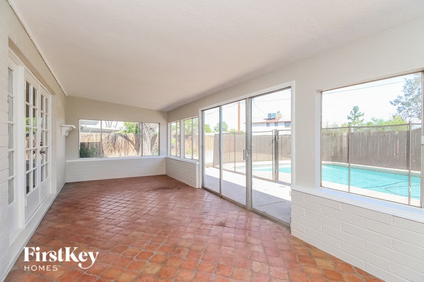 an empty living room with large windows and a pool