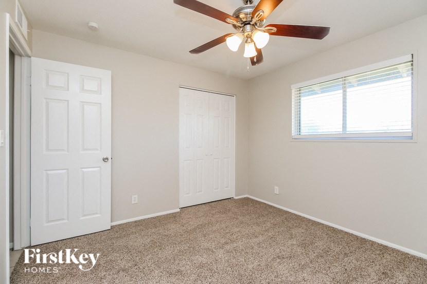 a bedroom with a ceiling fan and a closet