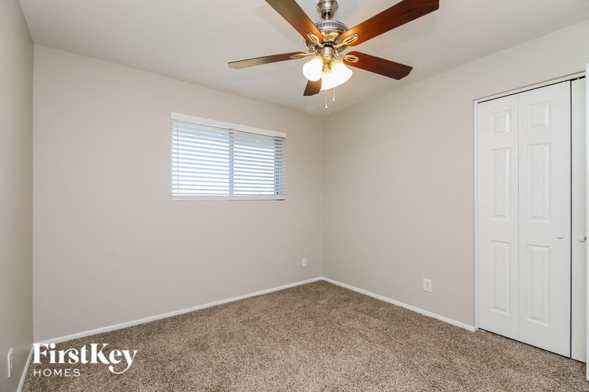 the master bedroom has a ceiling fan and a closet