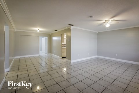 an empty living room with tile flooring and white walls