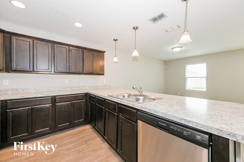 A kitchen with dark brown cabinets and a stainless steel dishwasher.