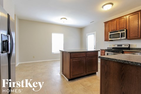 A kitchen with wooden cabinets and a refrigerator.
