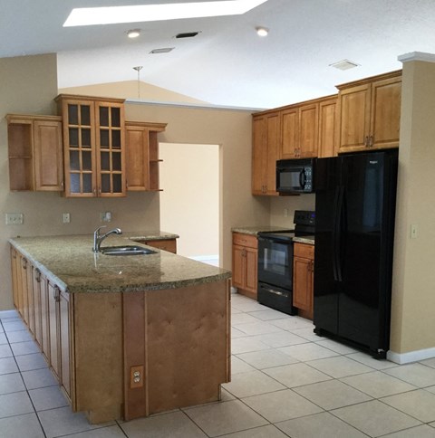 A kitchen with wooden cabinets and a granite countertop.