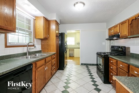 A kitchen with wooden cabinets and black appliances.