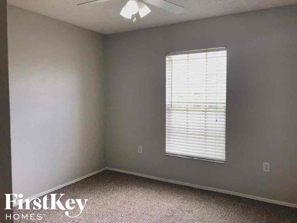 an empty room with a window and a ceiling fan