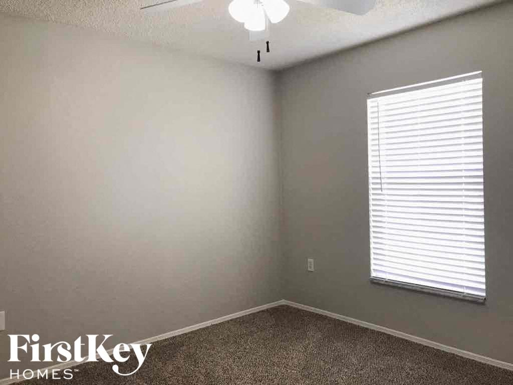 an empty room with a window and a ceiling fan
