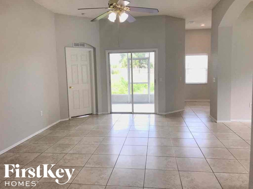 an empty living room with a ceiling fan