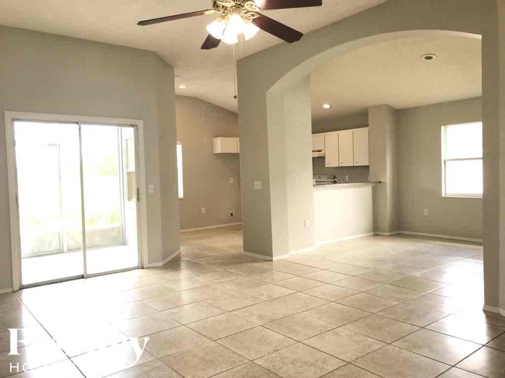 an empty kitchen and living room with a ceiling fan
