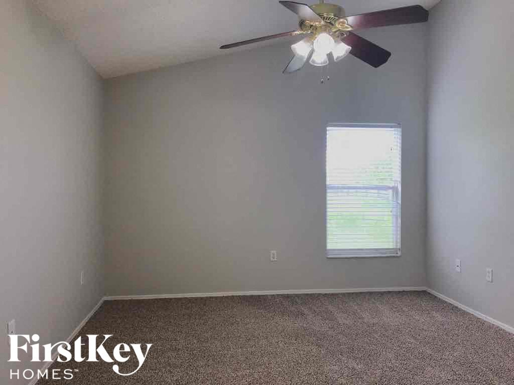 an empty room with a ceiling fan and a window