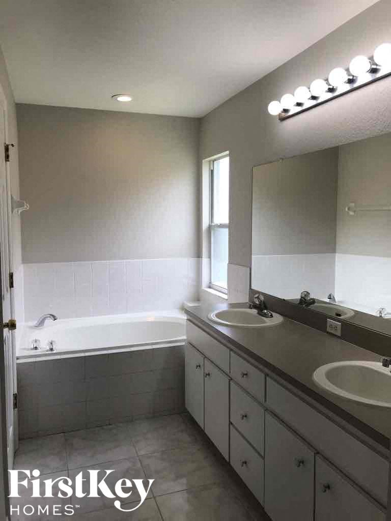 a bathroom with two sinks and a bath tub