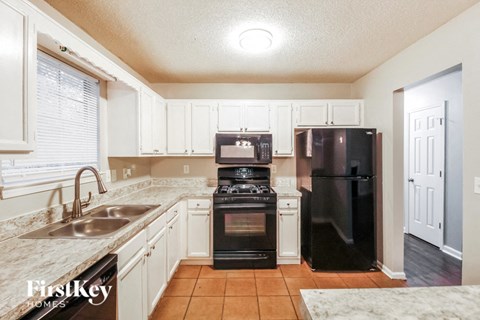 a kitchen with black appliances and white cabinets