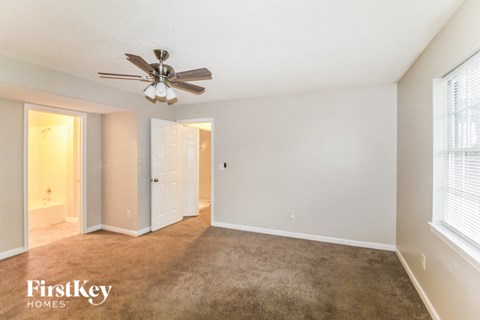 a living room with a carpet and a ceiling fan