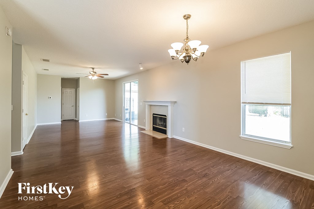 an empty living room with wood floors and a fireplace