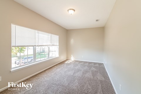 a spacious living room with carpet and a large window