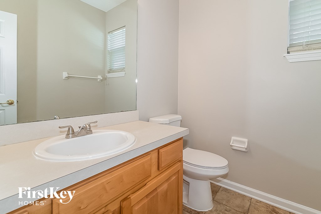 a bathroom with a sink toilet and a mirror