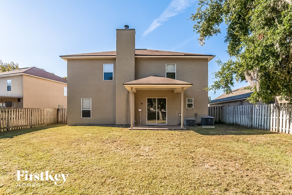 the backyard of a house with a yard and a white fence