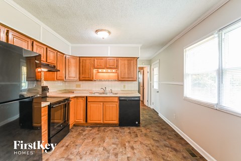 A kitchen with wooden cabinets and black appliances.