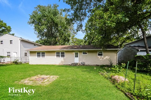 A house with a lawn and trees in the background.