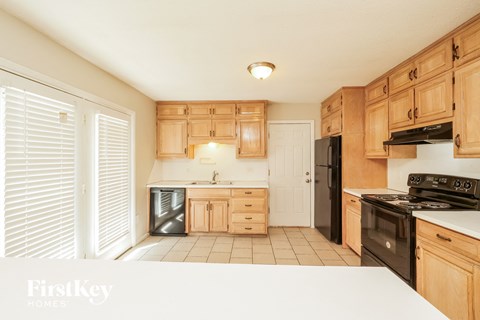 A kitchen with wooden cabinets and black appliances.