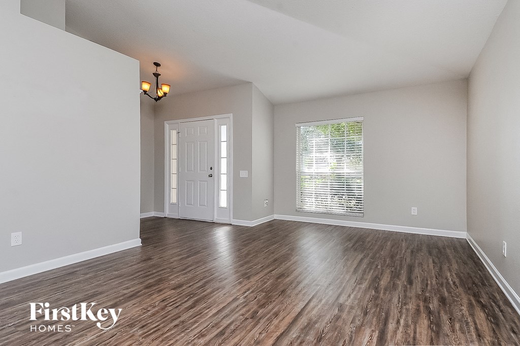 the living room and dining room of a house with wood flooring