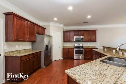 a kitchen with wooden cabinets and granite counter tops and stainless steel appliances