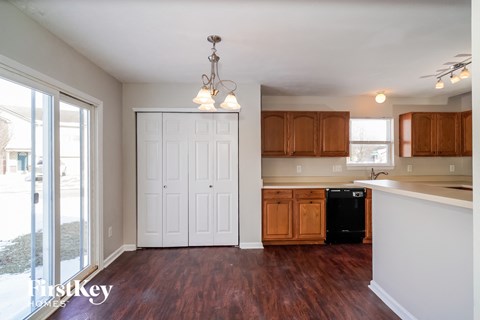 A kitchen with wooden cabinets and a black fridge.