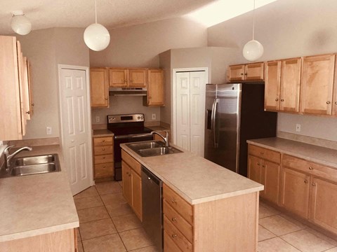 a kitchen with wooden cabinets and stainless steel appliances