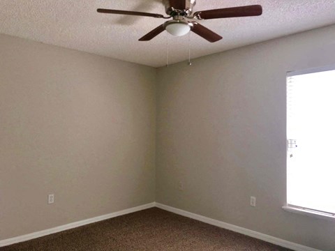 a living room with a ceiling fan and a window