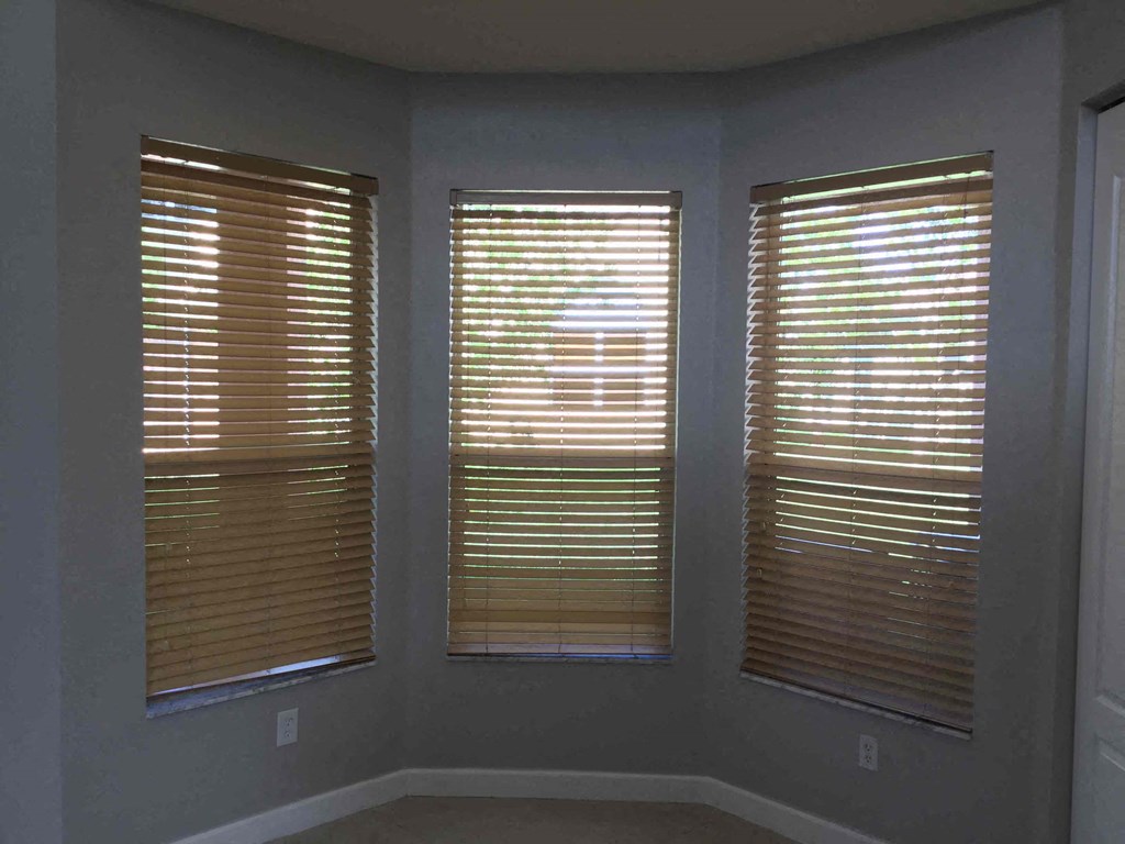 a view of three windows with blinds in a room