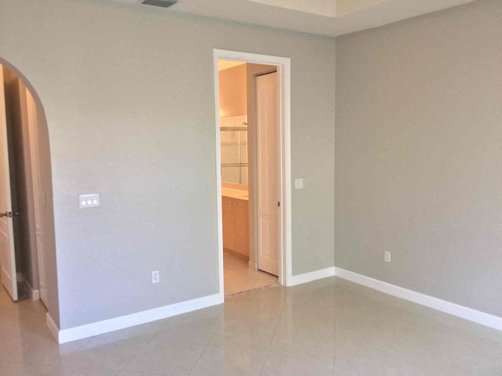 an empty living room with a door to a bathroom