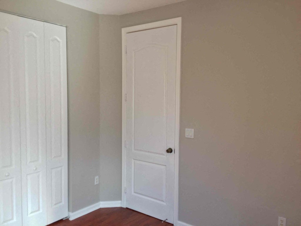 a room with a door and two closet doors