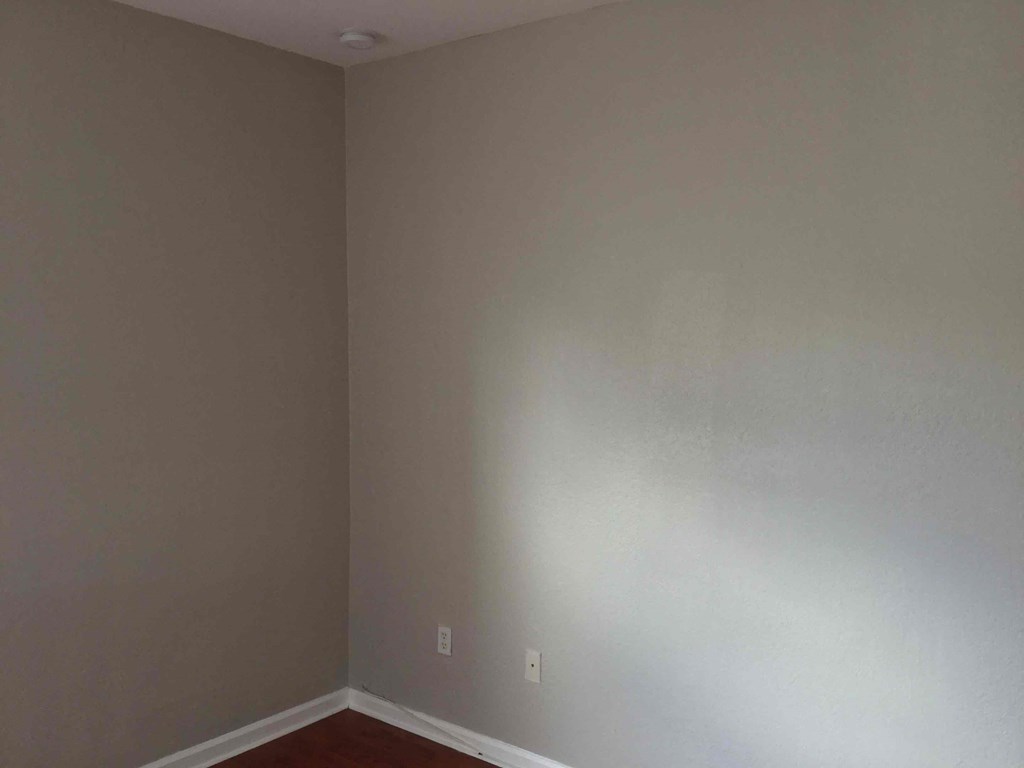 an empty room with white walls and a red floor
