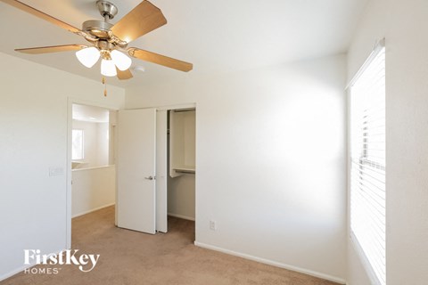 a bedroom with a ceiling fan and a closet
