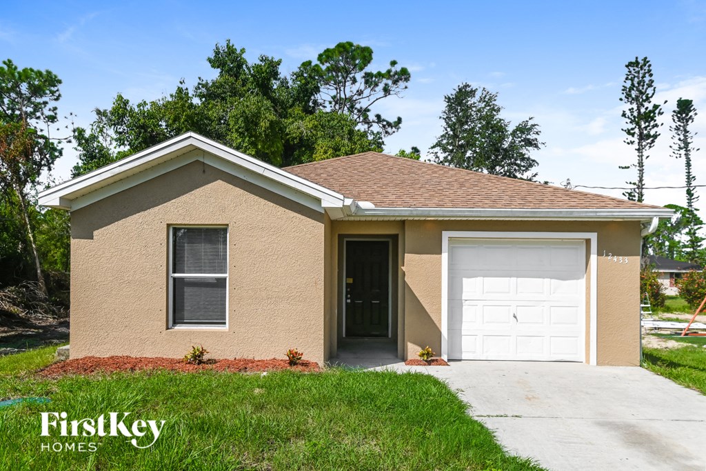 a tan brick house with a white garage door