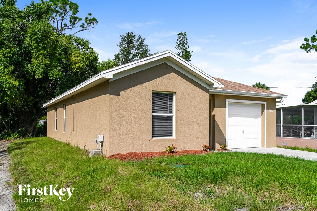 a small tan brick house with a white garage door