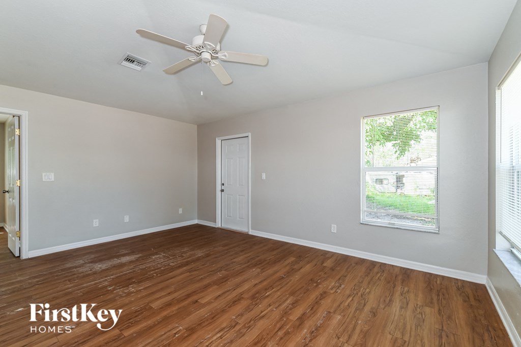 a living room with wood floors and a ceiling fan