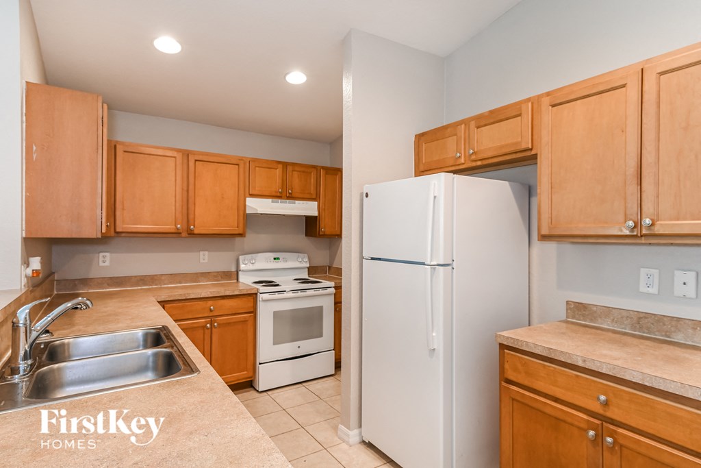 a kitchen with wooden cabinets and white appliances and a refrigerator