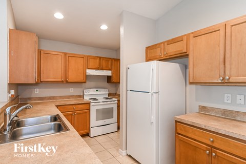 a kitchen with wooden cabinets and white appliances and a refrigerator
