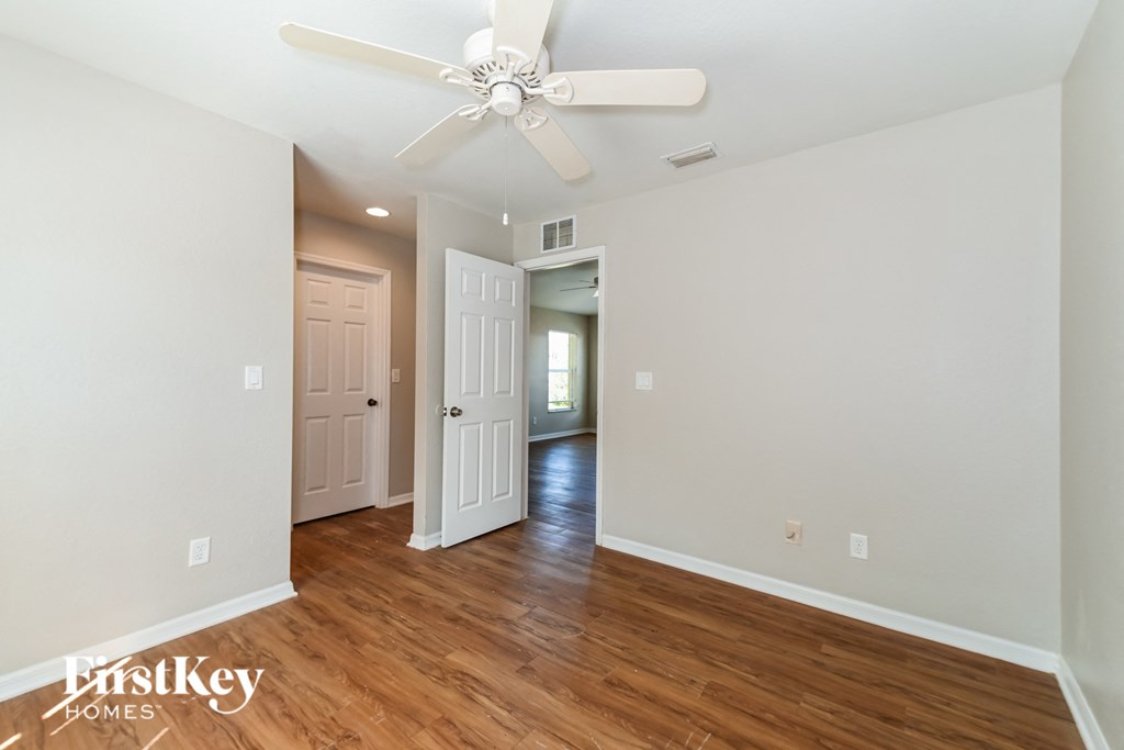 a living room with hardwood floors and a ceiling fan